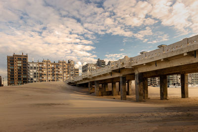 Panoramic view of beach by buildings against sky