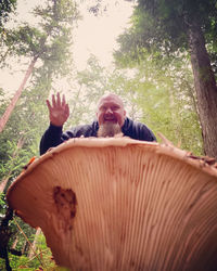 Portrait of man sitting on tree