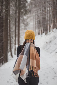 Portrait of woman standing on snow covered land