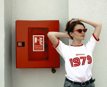 Mid adult woman standing against wall