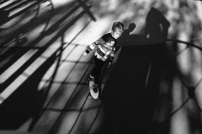 High angle view of cute boy skateboarding on road