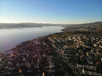 High angle view of townscape by sea against sky