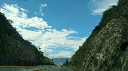 Road amidst trees against sky