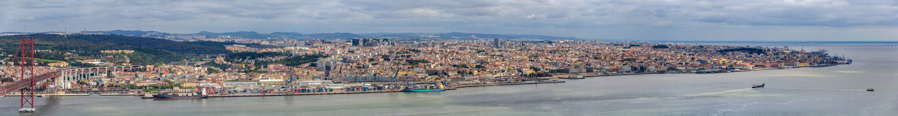 High angle view of cityscape by sea against sky