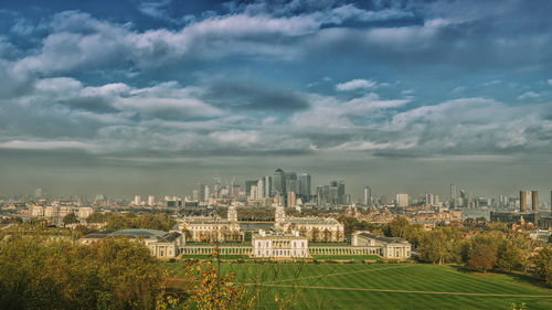 View of cityscape against cloudy sky