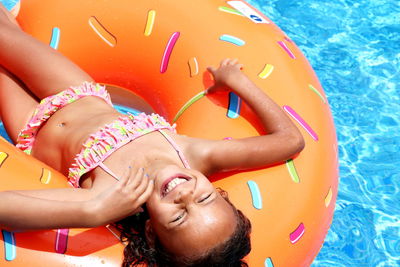 Portrait of smiling woman lying in swimming pool