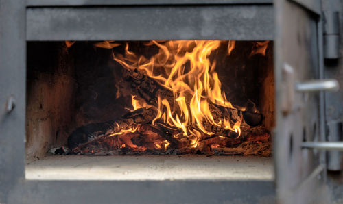 Open fireplace with high yellow flames beating out of bushwood logs