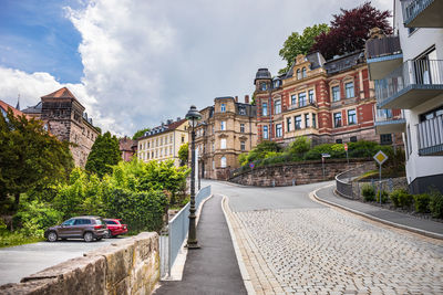 Street amidst buildings against sky in city