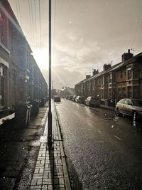 Road amidst buildings in city against sky