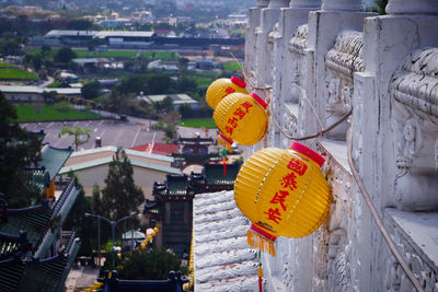 Illuminated lanterns hanging by buildings in city