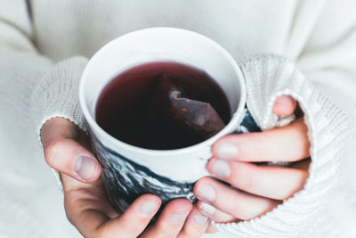 Close-up of hand holding coffee cup