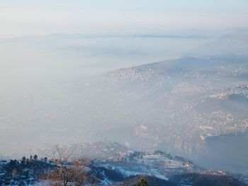 Aerial view of city and mountains against sky