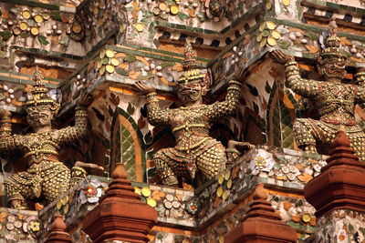 Low angle view of demon statues at wat arun temple