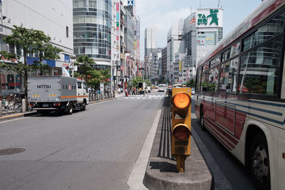 Vehicles on road against sky in city