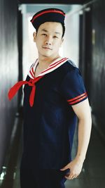 Portrait of mid adult man wearing uniform while standing in corridor 