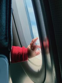 Close-up of baby hand by airplane window
