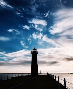 Lighthouse by sea against sky