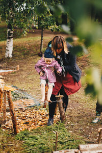 Woman with umbrella walking on street amidst trees
