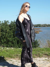 Young woman standing on land against sky
