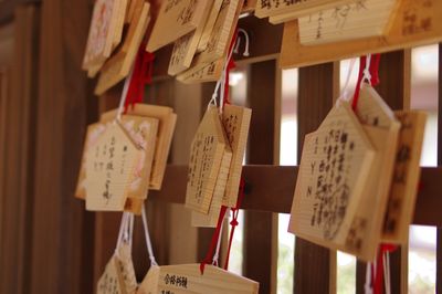 Close-up of prayer cards hanging at shrine