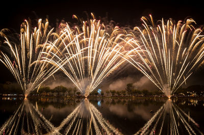 Panoramic view of firework display over lake at night