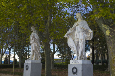 Statue in cemetery against trees in park