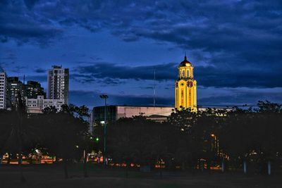 Illuminated cityscape against cloudy sky