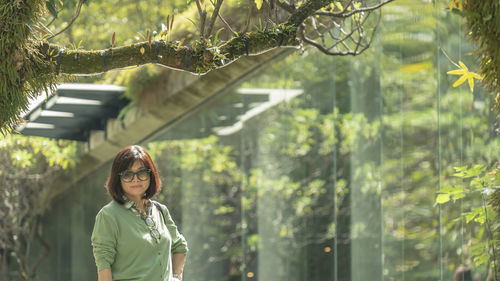 Portrait of woman standing against plants