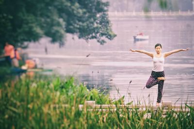 Woman doing yoga against lake