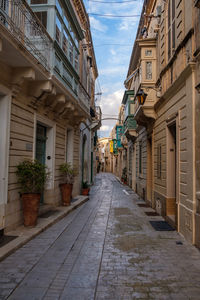 Empty alley amidst buildings in city