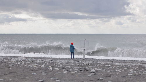 Full length of man standing on beach against sky