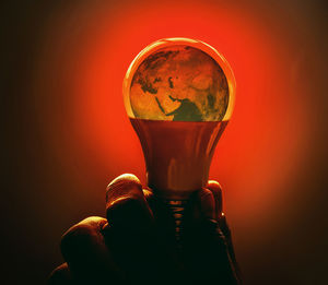 Close-up of hand holding glass against black background