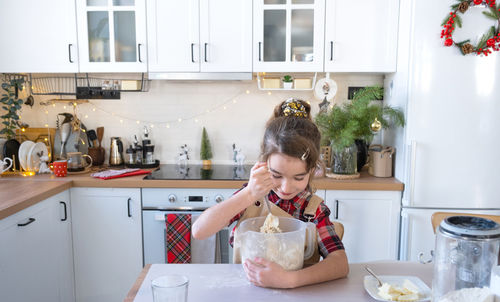 Young woman drinking milk in kitchen