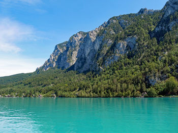 Scenic view of sea and mountains against blue sky