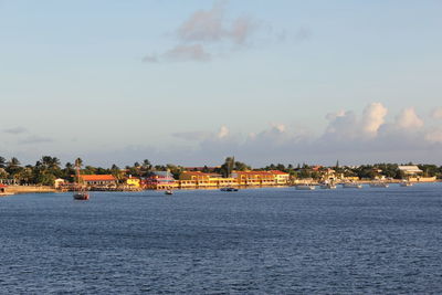 Scenic view of sea by buildings against sky