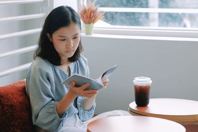 Girl looking away while sitting on mobile phone