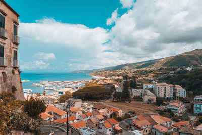 High angle view of townscape by sea against sky