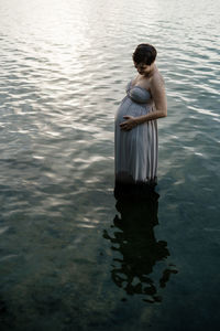 Rear view of woman standing in lake