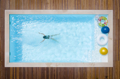 Girl swimming in pool on sunny day