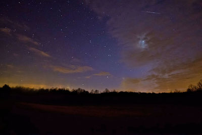 Scenic view of silhouette trees against sky at night