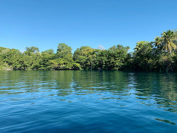 Scenic view of lake against clear blue sky