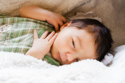 Close-up of baby lying on bed