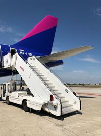 Airplane on airport runway against blue sky
