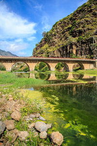 Arch bridge over river against sky