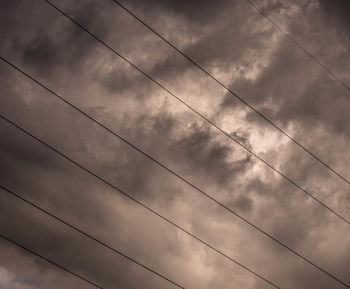 Low angle view of power lines against sky
