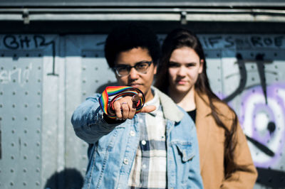 Portrait of couple standing against wall