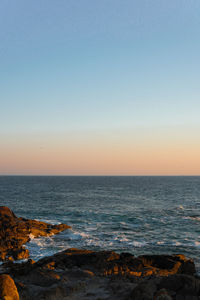 Scenic view of sea against clear sky during sunset