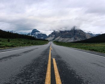 Country road against cloudy sky