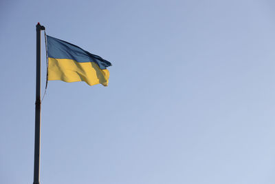 Low angle view of flag against clear sky