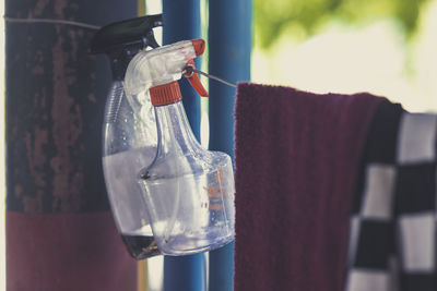 Close-up of bottle and clothes hanging on clothesline